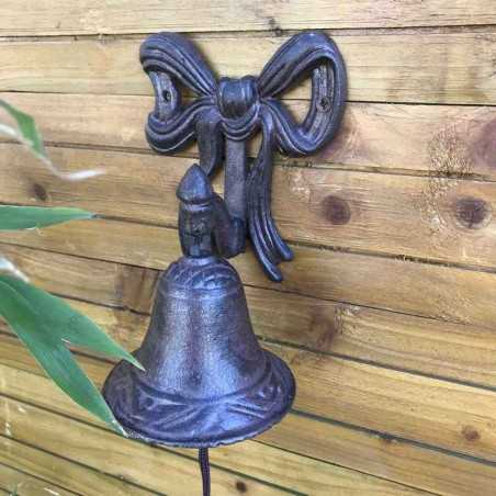Gietijzeren deurbel voor tuinpoort met strikmotief, sfeervol gepresenteerd