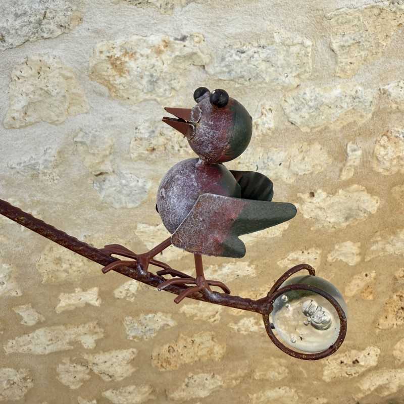 Metalen tuinmobiel met patina, zicht op het contragewicht van glas